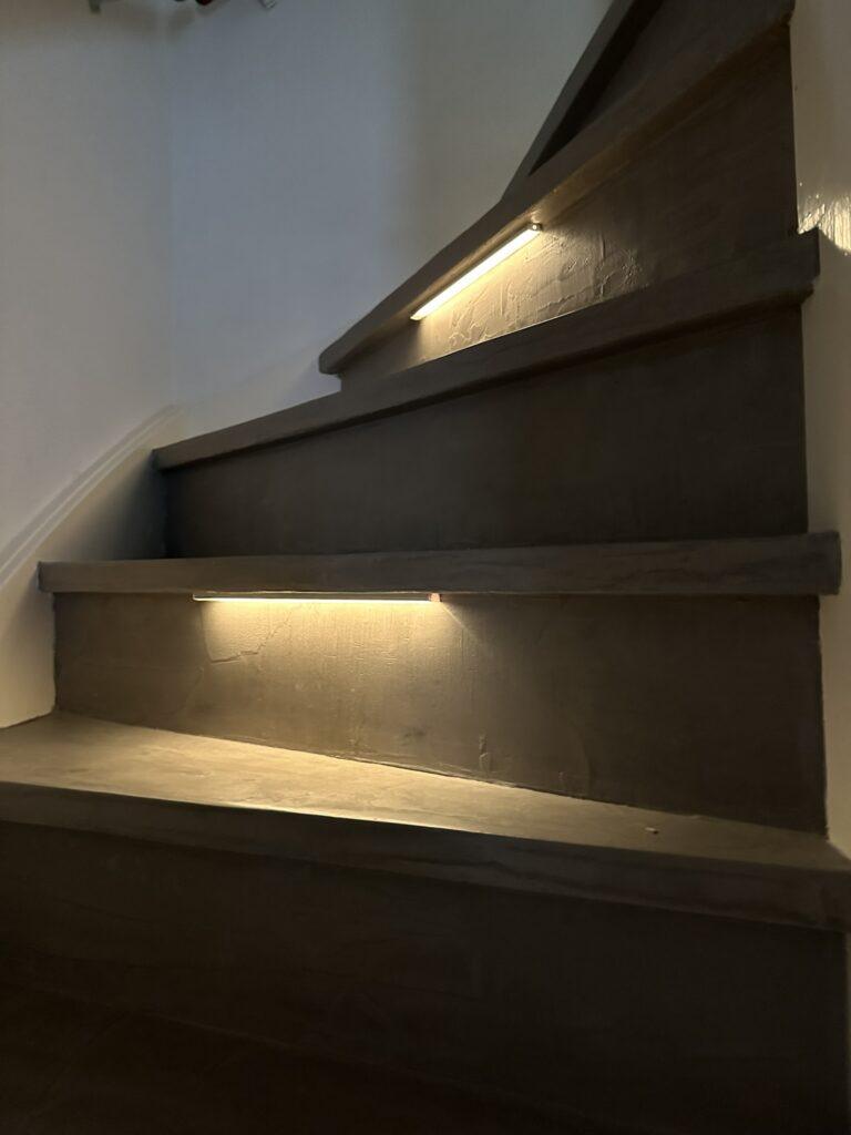 Traprenovatie met betonafwerking en LED strips onder de treden