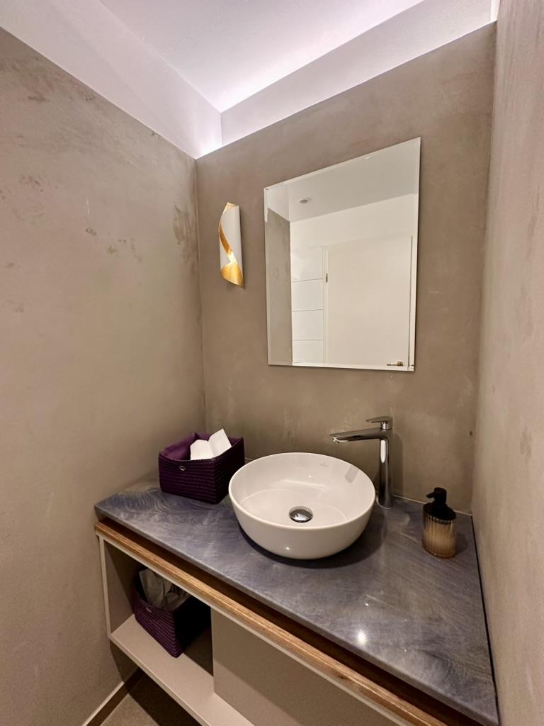Toilet in beton ciré met wastafel en spiegel