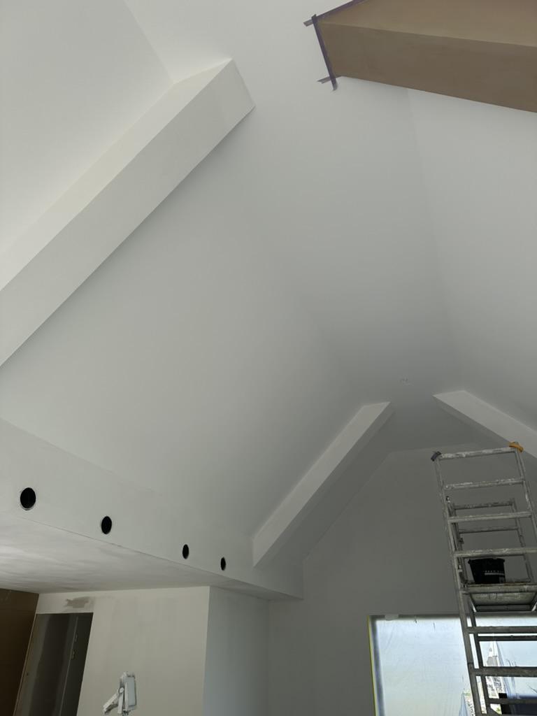 Glad pleisterwerk plafond met balken in woning